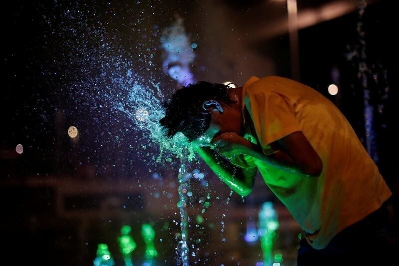 A Honduran boy, part of a caravan of thousands of migrants from Central America en route to the United States, plays with water fountains along the sidewalks of Tapachula city center, Mexico October 21, 2018.