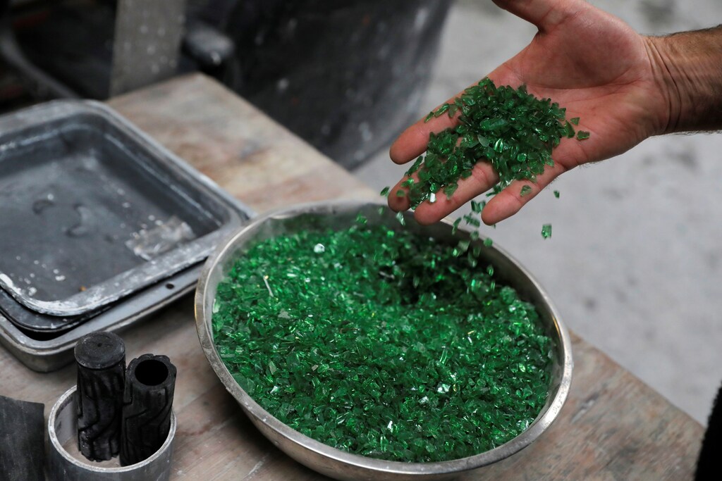 A worker displays recycled glass in the factory at IceStone, a manufacturer of recycled glass countertops and surfaces, in New York City, New York, U.S., June 3, 2021. REUTERS/Andrew Kelly - RC20TN9KATE3