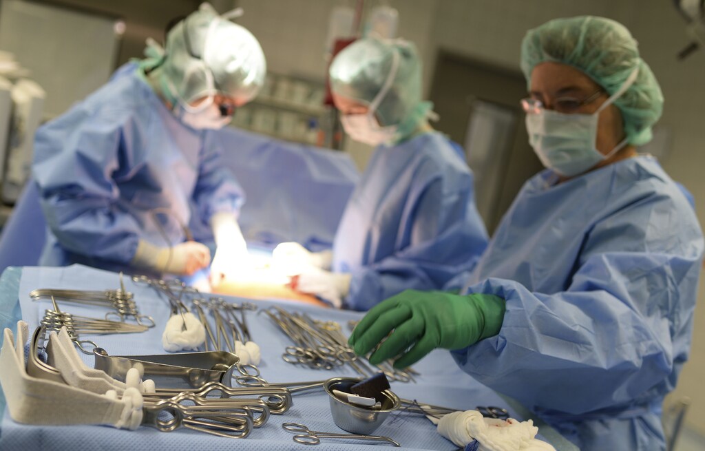 Surgeons of the general and visceral surgery at the Asklepios Hospital Hamburg-Barmbek, open the abdominal wall of a patient during liver surgery, one of the first surgeries of its kind in Germany with the support of a tablet computer to access and visualize planning data, in Hamburg August 15, 2013. The tablet computer uses augmented reality, which allows the liver to be filmed with an iPad and overlaid during an operation with virtual 3D models reconstructed from the real organ. Developed by Fraunhofer MEVIS in Bremen, this procedure helps locate critical structures such as tumors and vessels and is expected to improve the quality of transferring pre-operational resection plans into actual surgery. REUTERS/Fabian Bimmer (GERMANY - Tags: HEALTH) - BM2E98G1GFN01