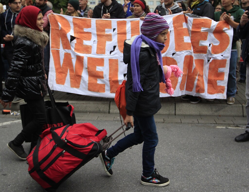 Migrants are welcomed as they arrive at the main railway station in Dortmund, Germany September 6, 2015. Austria and Germany threw open their borders to thousands of exhausted migrants on Saturday, bussed to the Hungarian border by a right-wing government that had tried to stop them but was overwhelmed by the sheer numbers reaching Europe's frontiers. REUTERS/Ina Fassbender - RTX1RB7L