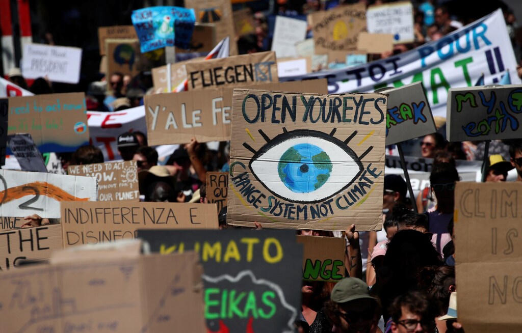 People hold up signs as they take part in a climate strike after the five-day Summer Meeting in Lausanne Europe (SMILE) of the Fridays for Future movement in Lausanne, Switzerland August 9, 2019. REUTERS/Denis Balibouse - RC1C431AA8F0