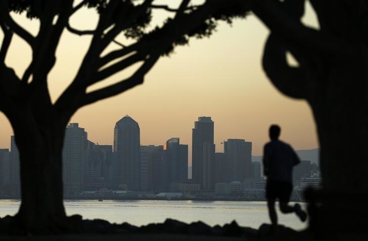A jogger runs along a park in front of the skyline of San Diego, California September 12, 2014. REUTERS/Mike Blake (UNITED STATES - Tags: CITYSCAPE ENVIRONMENT SOCIETY)