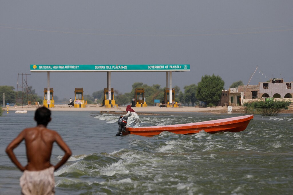 A man rides a boat past toll plaza amid flood water on main Indus highway, following rains and floods during the monsoon season in Sehwan, Pakistan, September 15, 2022. REUTERS/Akhtar Soomro/File Photo TPX IMAGES OF THE DAY SEARCH "GLOBAL POY" FOR THIS STORY. SEARCH "REUTERS POY" FOR ALL BEST OF 2022 PACKAGES.
