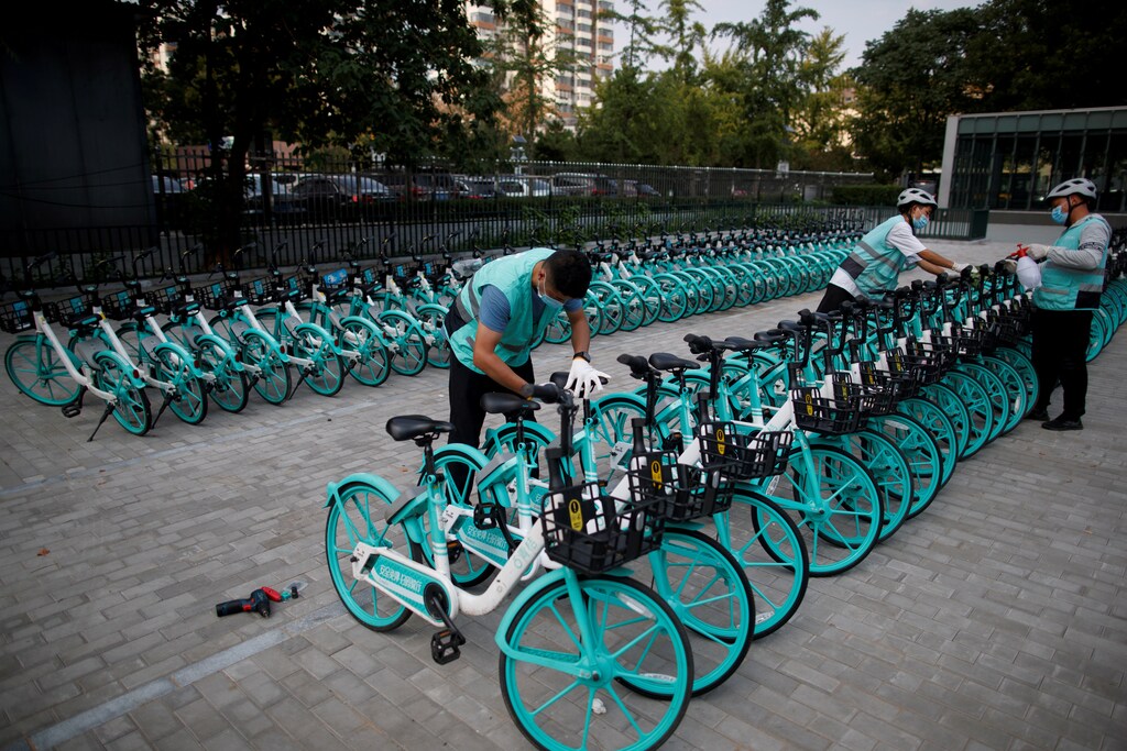 Staff members repair and disinfect Didi shared bicycles outside a subway station, following an outbreak of the coronavirus disease (COVID-19), in Beijing, China August 7, 2020. REUTERS/Thomas Peter REFILE - REMOVING ERRONEOUS INFORMATION - RC2X8I9Y4IZA