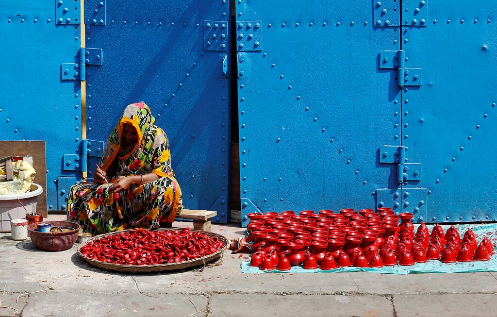 A woman paints earthen lamps which are used to decorate temples and homes during Diwali, the Hindu festival of lights, in Kolkata, India October 17, 2016. REUTERS/Rupak De Chowdhuri - RTX2P3TK