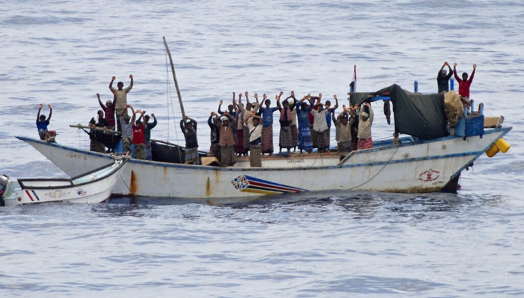 Hostages and pirates stand with their hands up before the intervention of Dutch NATO soldiers off Somalia's coast in this NATO handout photo made available April 18, 2009. Dutch commandos freed 20 Yemeni hostages on Saturday and briefly detained seven pirates who had forced the Yemenis to sail a "mother ship" attacking vessels in the Gulf of Aden, NATO officials said.