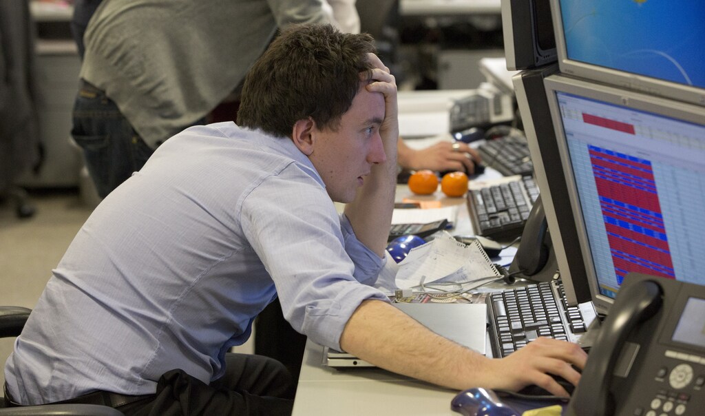 A trader looks at his screen on the IG Group trading floor in London March 18, 2013. The surprise decision by euro zone leaders to part-fund a bailout of Cyprus by taxing bank deposits sent shockwaves through financial markets on Monday, with shares and the bonds of struggling euro zone governments tumbling. REUTERS/Neil Hall (BRITAIN - Tags: BUSINESS POLITICS TPX IMAGES OF THE DAY) - RTR3F5E7