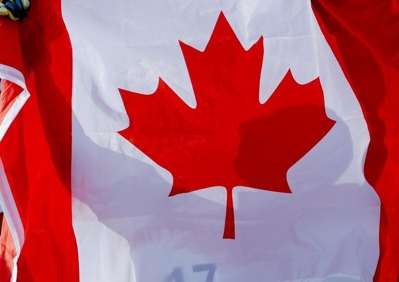 Alpine Skiing - FIS Alpine Skiing World Championships - Men's Downhill - St. Moritz, Switzerland - 12/2/17 - Canada's silver medalist Erik Guay lifts up a Canadian flag during the flower ceremony. REUTERS/Denis Balibouse - RTSYAL2