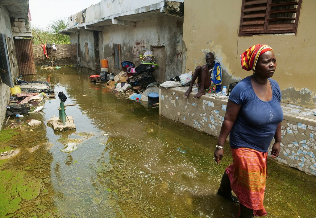 Mrs. Aicha Sy and Mr. Issa Camara, residents, are pictured in the flooded alley of their home after heavy rains in Yeumbeul district on the outskirts of Dakar, Senegal September 16, 2020. Picture taken September 16, 2020. REUTERS/Christophe Van Der Perre - RC2V4J9OM246