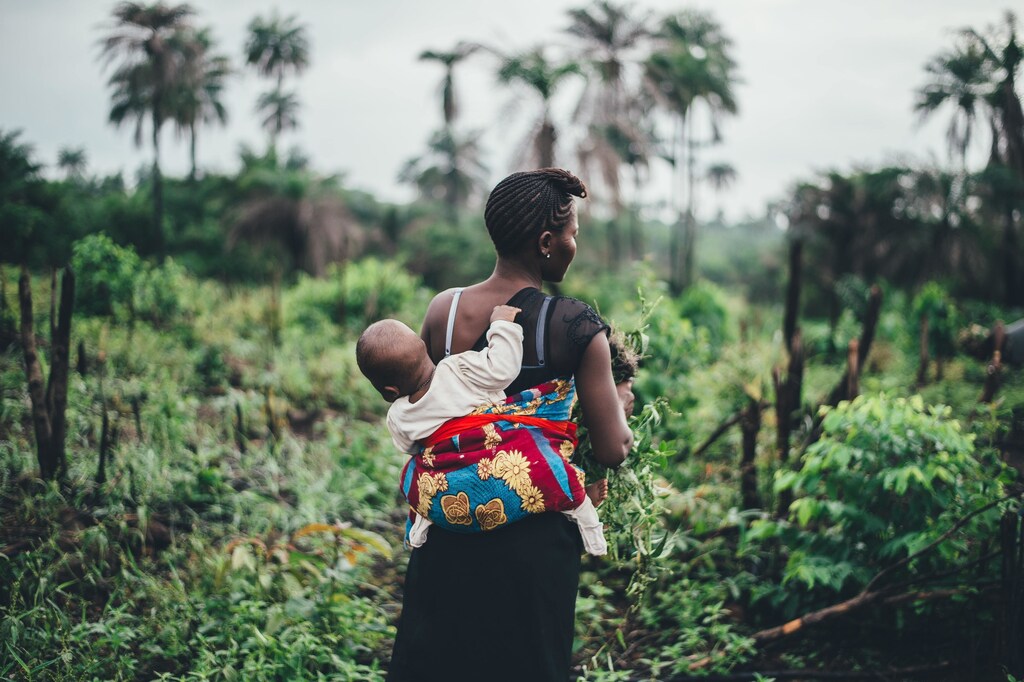 shown here is a woman working in a field in Africa while carrying her baby. In developing countries, research shows there are few formal jobs; a situation which could be improved by policies which better support people