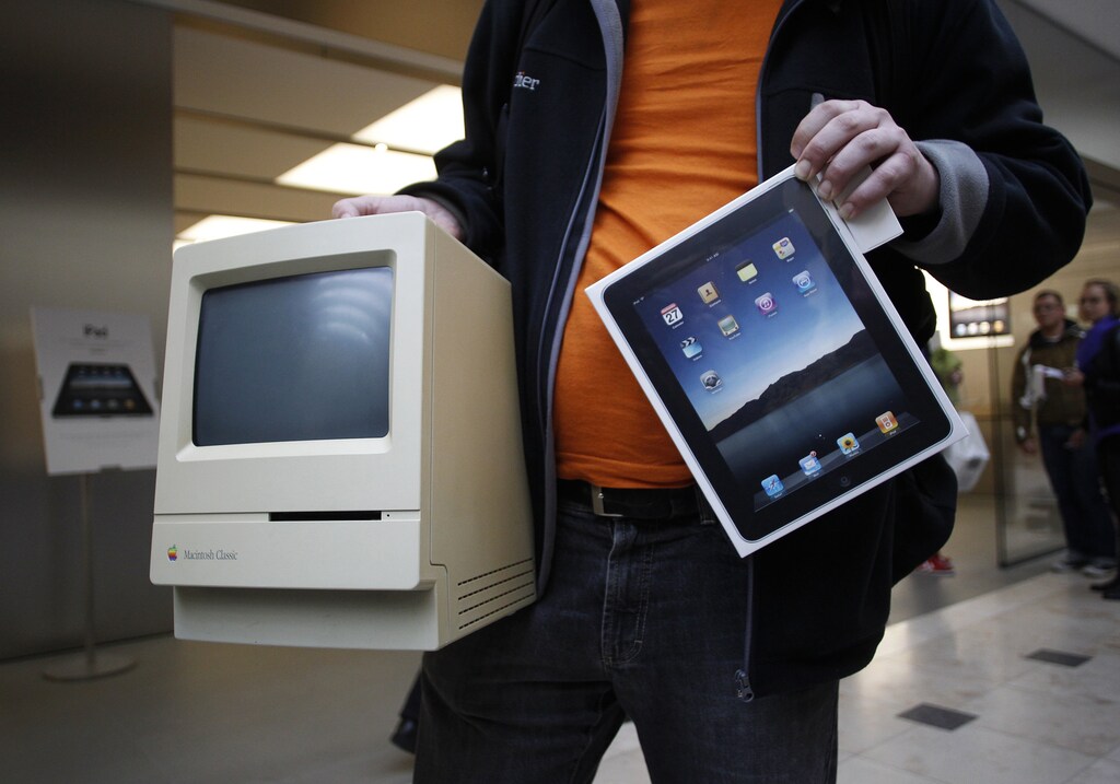 Hans-Henrik Duessel from Svendborg, Denmark, displays his old Apple Macintosh Classic computer from 1990 beside his newly purchased Apple iPad after being among the first to purchase the new device during an iPad launch event at the Apple retail store in Hamburg May 28, 2010. REUTERS/Christian Charisius (GERMANY - Tags: BUSINESS SOCIETY SCI TECH IMAGES OF THE DAY) - GM1E65S18WN01