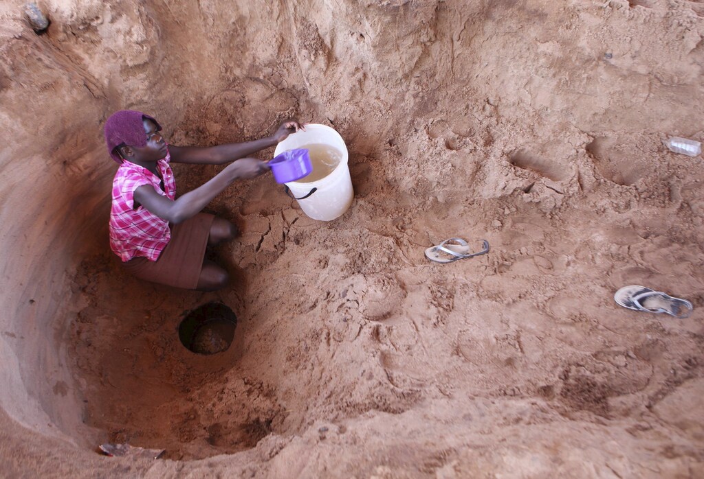 A woman fetches drinking water from a well along a dry Chemumvuri river near Gokwe, Zimbabwe, May 20, 2015. Southern Africa has suffered one of its worst harvests in years due to a lack of rain, prompting concerns about food shortages across the region. Picture taken May 20, 2015. To match ZIMBABWE-DROUGHT/ REUTERS/Philimon Bulawayo - RTX1E5QX