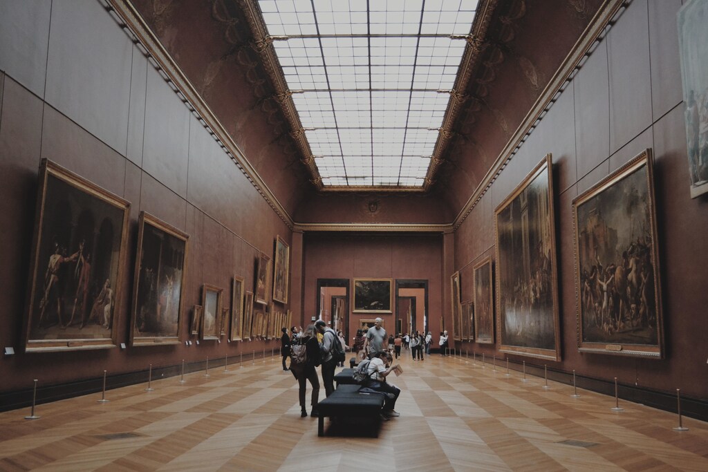 People looking at paintings in a museum
