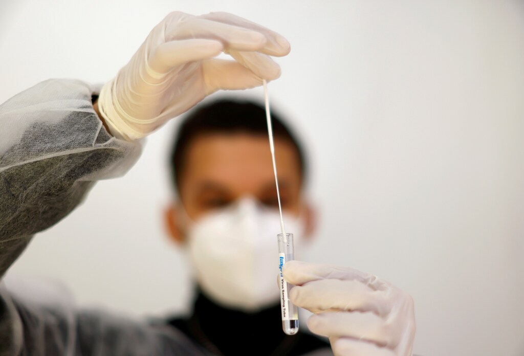 FILE PHOTO: A medical worker holds a test-tube after administering a nasal swab to a patient at a coronavirus disease (COVID-19) testing centre in Nice, France, November 23, 2021. REUTERS/Eric Gaillard/File Photo