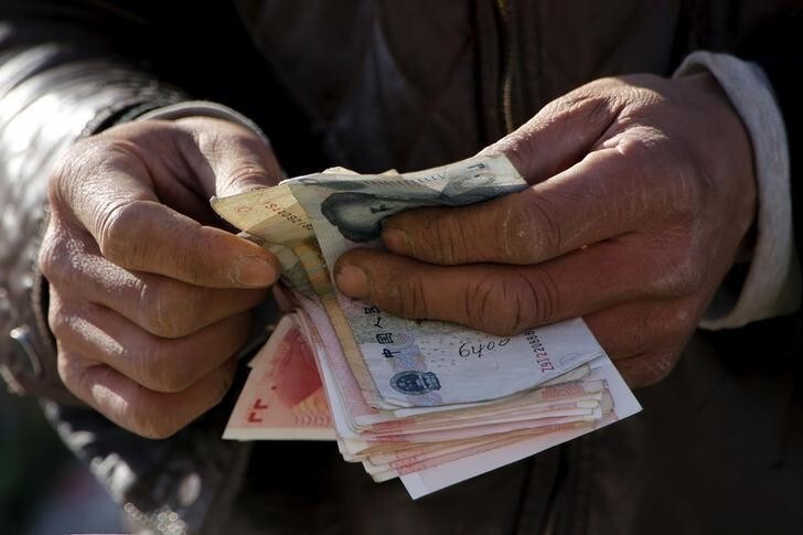 A vegetable vendor counts his money at a market in Beijing, China, March 10, 2016. REUTERS/Kim Kyung-Hoon/File Photo GLOBAL BUSINESS WEEK AHEAD PACKAGE Ð SEARCH ÒBUSINESS WEEK AHEAD 5 SEPTEMBERÓ FOR ALL IMAGES