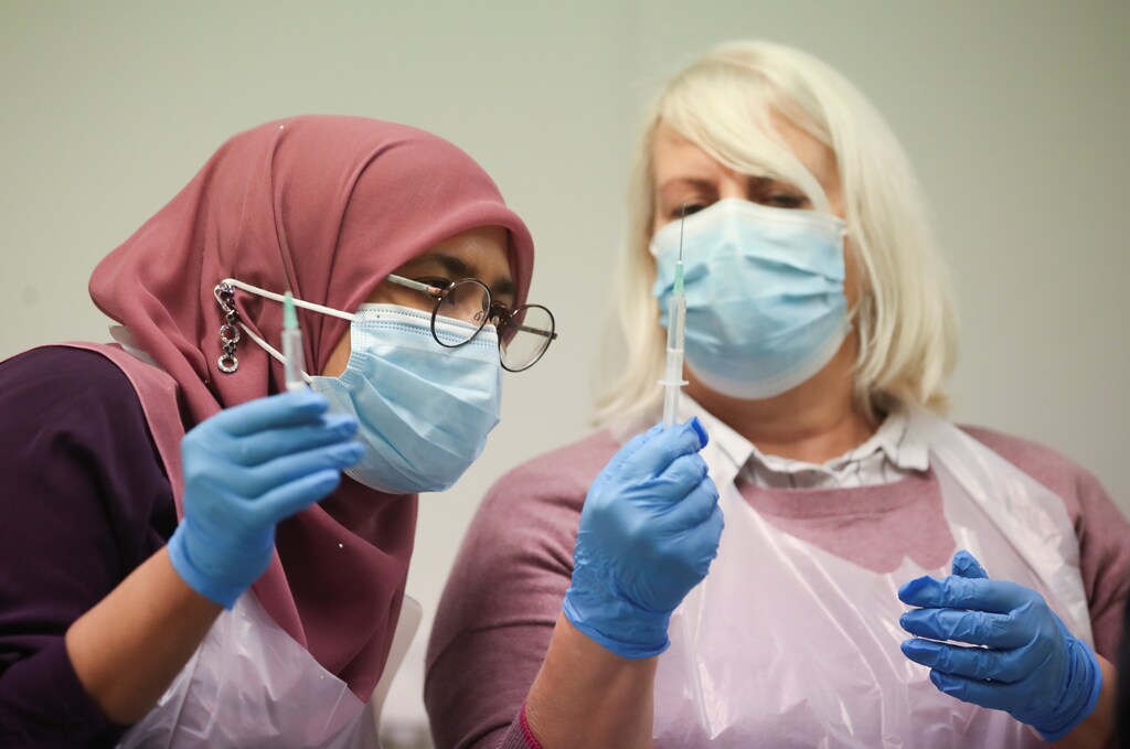 Pharmacy staff members prepare COVID-19 vaccines
