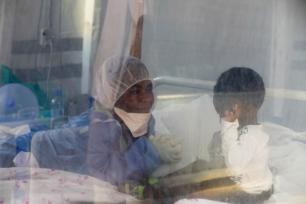 Noella Masika Vinyinyi, 30, an Ebola survivor who works as a caregiver, takes care of Angeline Kalala, 1, who is suspected to be suffering from Ebola, inside the Biosecure Emergency Care Unit (CUBE) at an Ebola treatment centre (ETC) in Katwa, near Butembo, in the Democratic Republic of Congo, October 3, 2019. Masika survived Ebola in June 2019. She lost 17 family members to Ebola, including both parents and two grandparents, but she counts herself fortunate to have survived. "I feel compassionate and grateful for the care I received," she said. "I feel an obligation to contribute to the fight against Ebola." REUTERS/Zohra Bensemra SEARCH "EBOLA ZOHRA" FOR THIS STORY. SEARCH "WIDER IMAGE" FOR ALL STORIES. - RC135078D6A0