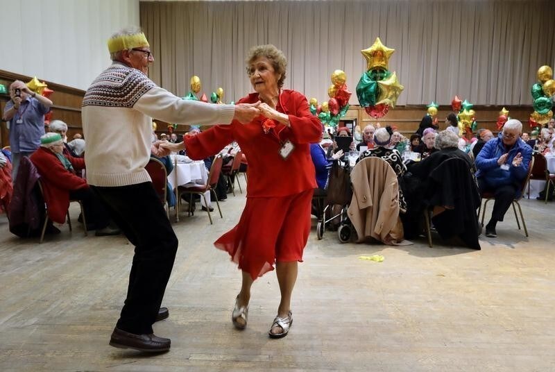 Anita Monk and her neighbour John Everett dance during a Christmas Dinner event for older people at Hammersmith and Fulham Town Hall in London, Britain December 25, 2016.