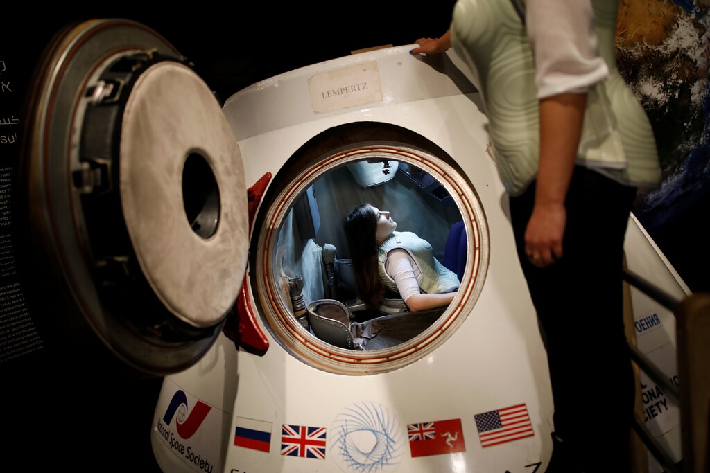 A woman wearing a prototype of Stemrad's new protective vest, Astrorad, sits inside Russian spacecraft, Excalibur-Almaz Space Capsule, during a demonstration for Reuters, at Madatech, National Museum of Science Technology and Space in Haifa, Israel February 23, 2017. Picture taken February 23, 2017. REUTERS/Amir Cohen - RTS119FT