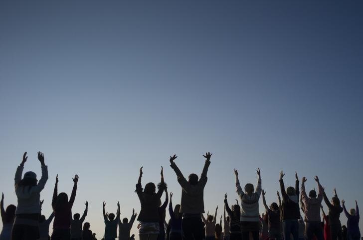 Revellers perform yoga as they celebrate the summer solstice on Salisbury Plain in southern England June 21, 2014. Stonehenge is a celebrated venue of festivities during the summer solstice - the longest day of the year in the northern hemisphere - and it attracts thousands of revellers, spiritualists and tourists. Druids, a pagan religious order dating back to Celtic Britain, believe Stonehenge was a centre of spiritualism more than 2,000 years ago. REUTERS/Kieran Doherty (BRITAIN - Tags: SOCIETY ENVIRONMENT)
