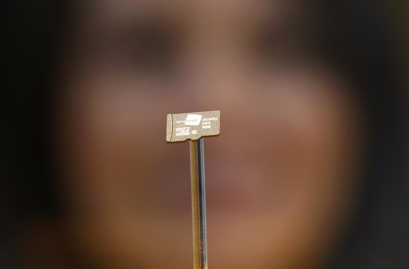 A woman looks at a data chip containing encryption codes for mobile and landline phones at the booth of Secusmart during the CeBIT trade fair in Hanover March 8, 2014. The German company Secusmart is known for supplying German Chancellor Angela Merkel with a secure mobile phone.
