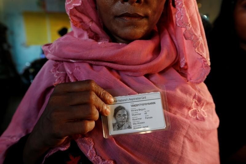 Rohingya refugee woman poses after receiving an ID card from Bangladesh army in a camp near Cox's Bazar, Bangladesh October 10, 2017.