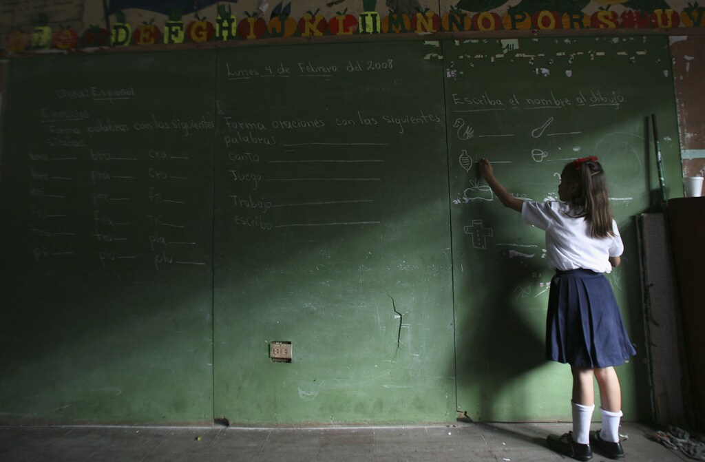 A girl writes on a chalk board during the opening of the elementary school year in the old center of Managua February 4, 2008. REUTERS/Oswaldo Rivas (NICARAGUA) - RTR1WP1F