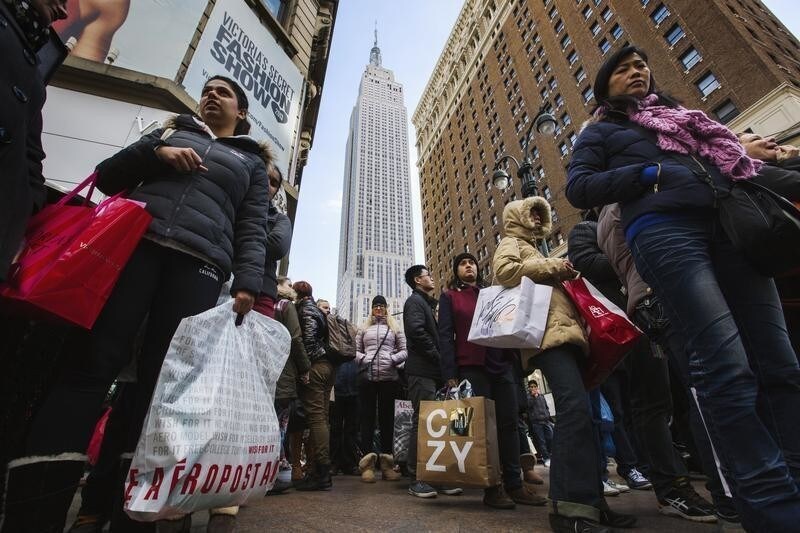 Pedestrians stand with shopping bags as they wait to cross a street during Black Friday sales in New York, November 29, 2013. Black Friday, the day following Thanksgiving Day holiday, has traditionally been the busiest shopping day in the United States. REUTERS/Lucas Jackson (UNITED STATES - Tags: BUSINESS) - GM1E9BU05ZC01