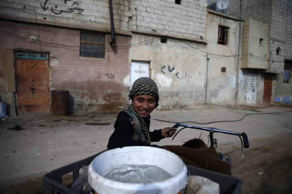 A boy transports water on a bicycle in the rebel-held besieged Douma neighbourhood of Damascus, Syria February 15, 2017