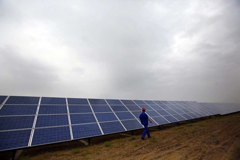 A worker inspects solar panels at a solar farm in Dunhuang, 950km (590 miles) northwest of Lanzhou, Gansu Province September 15, 2013. China is pumping investment into wind power, which is more cost-competitive than solar energy and partly able to compete with coal and gas. China is the world's biggest producer of CO2 emissions, but is also the world's leading generator of renewable electricity. Environmental issues will be under the spotlight during a working group of the Intergovernmental Panel on Climate Change, which will meet in Stockholm from September 23-26. REUTERS/Carlos Barria (CHINA - Tags: ENERGY BUSINESS ENVIRONMENT) - RTX13UF9