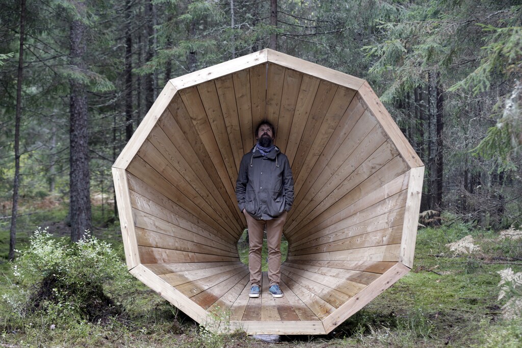 Head of the department of the interior architecture at Estonian Academy of Arts Hannes Praks poses for a picture in the wooden megaphone in the forest near Pahni village, Estonia, September 28, 2015. If you go down to the woods in Estonia today, you're sure of a big surprise: three large-scale wooden megaphones have been set up by architecture students for visitors to climb inside. Professors at the Estonian Academy of Arts' architecture department sent students into the forest to find inspiration to create a forest library. But student Birgit Oigus, realising that preserving books outdoors in the Estonian autumn and winter would be nigh-on impossible, decided to think outside the box. Picture taken September 28, 2015. REUTERS/Ints Kalnins TPX IMAGES OF THE DAY - GF10000226076