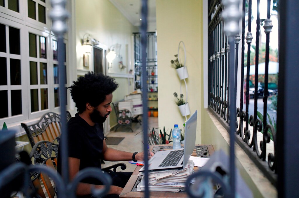 Alexander Caiafas, a 25 year-old data analyst, is seen working through a window into his home in Ikoyi, as authorities around the world impose various guidelines on lockdowns and social distancing to curb the spread of coronavirus disease (COVID-19), in Lagos, Nigeria May 25, 2020. When asked, what will you miss most about being in lockdown? Alexander replied: ' Spending quality time with relatives and parents because you know, thatÃs often hard to do. Secondly, I would say I miss speaking over the phone to close friends like on FaceTime, HouseParty, Zoom, all those kinds of applications'. Picture taken May 25, 2020. REUTERS/Temilade Adelaja - RC2LXG98YSTW