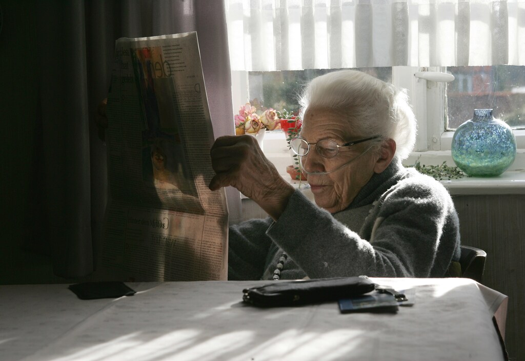 Ilse Westphal, 92-year-old, reads the newspapers as she receives her daily oxygen therapy for a chronic pulmonary disease, in the living room of her farmhouse in the small village of Gross Lafferde near Hanover, northern Germany, April 15, 2006. REUTERS/Christian Charisius - RTR1CKX6