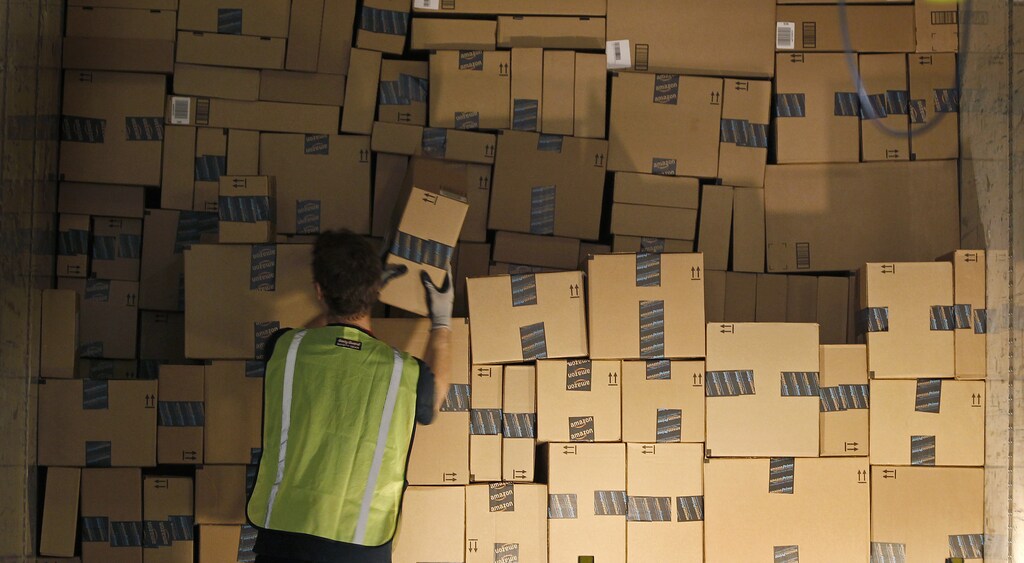 A worker stacks a shipping trailer with boxed items for delivery at Amazon's distribution center in Phoenix, Arizona November 22, 2013. The web-based retailer is preparing for Cyber Monday, traditionally the busiest day of the year for online purchases, which falls on December 2 in 2013. REUTERS/Ralph D. Freso (UNITED STATES - Tags: BUSINESS EMPLOYMENT) - GM1E9BN0UTE01