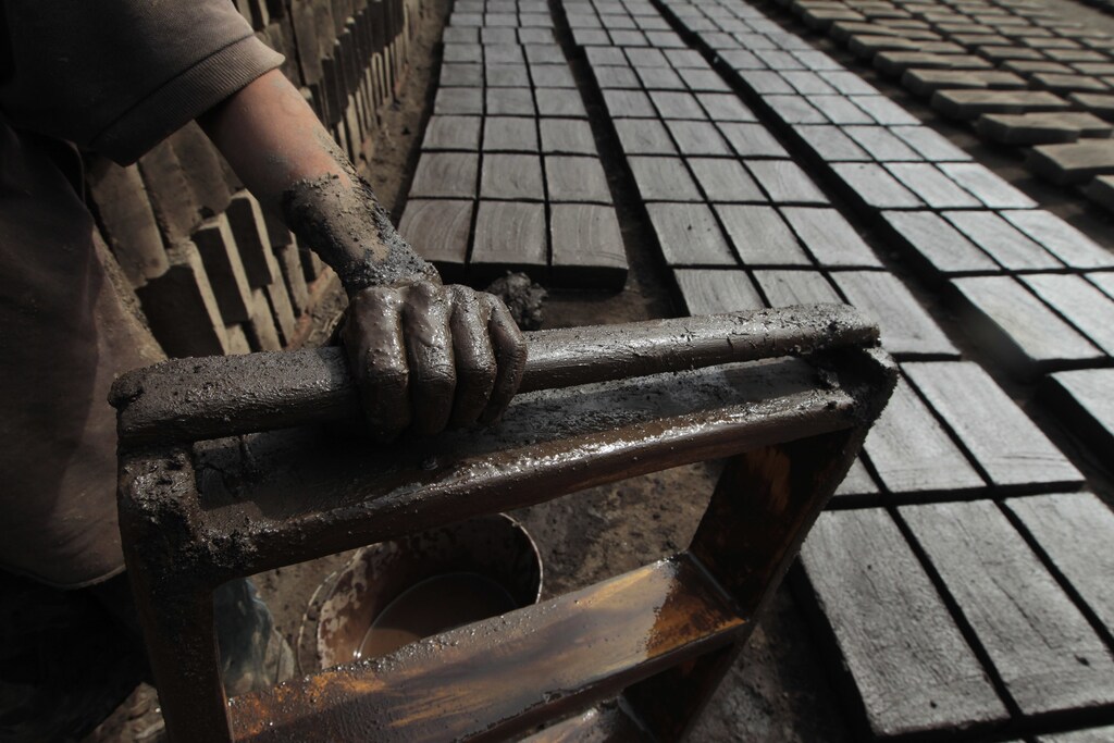 A child makes bricks at a brick-making factory in La Paz Centro town, about 62 km (39 miles) west of Managua August 20, 2013. Eficiencia Energetica en Ladrilleras Artesanales de America Latina (EELA), reported that Nicaraguan brick makers burn 47,869 metric tons of fire wood, which produces 65,874 metric tons of carbon dioxide every year. The country has 467 brick makers located mostly on the west coast of Nicaragua according to local media. REUTERS/Oswaldo Rivas (NICARAGUA - Tags: BUSINESS EMPLOYMENT) - GM1E98L0L7W01