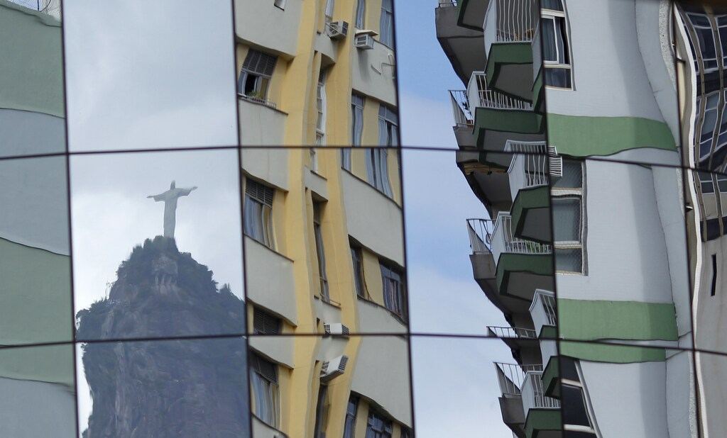 Rio de Janeiro's famous "Christ the Redeemer" statue is reflected on the glass facade of a building in Botafogo in Rio de Janeiro February 25, 2011. Rio, boasting picture-postcard scenery and plans for big investments ahead of the World Cup in 2014 and the Olympic Games two years later, is not alone in a Brazilian housing boom that is inevitably raising fears of an asset bubble in one of the world's hottest emerging markets. Picture taken February 25, 2011. To match Feature BRAZIL-HOUSING/ REUTERS/Ricardo Moraes (BRAZIL - Tags: BUSINESS CITYSCAPE) - GM1E73P10ML01