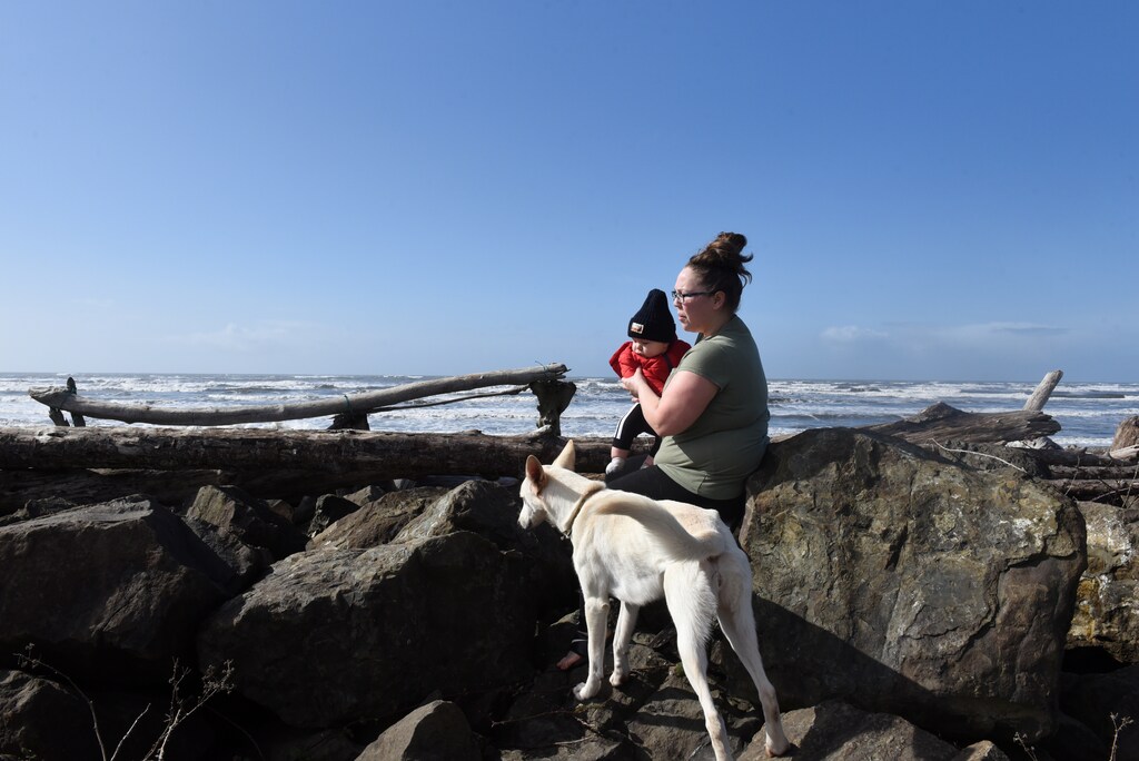 Sonya Hall, a homemaker, and her 11-month-old son Sa'keeli Willis, sit on the sea wall, damaged by storm surges and high tides, behind her house on the Quinault Indian Reservation in Taholah, Washington, U.S., March 4, 2020. ''These rocks here, these are fully intact but if you look towards our river, the waves go over them almost every single night, so it goes into our river and then the river overflows and then our streets overflow. Once our streets overflow, it will fill in our homes and then this whole street will be taken and it's possible to happen every time there's a high tide,'' Hall said. REUTERS/Stephanie Keith SEARCH ''QUINAULT CLIMATE CHANGE'' FOR THIS STORY. SEARCH ''WIDER IMAGE'' FOR ALL STORIES.