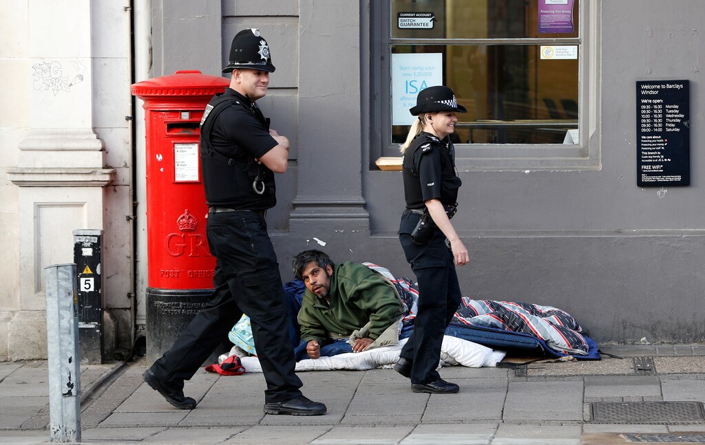 Police officers search an area next to a homeless man a day ahead of the royal wedding between Princess Eugenie and Jack Brooksbank in Windsor, Britain, October 11, 2018. REUTERS/Darren Staples - RC145AA12E10