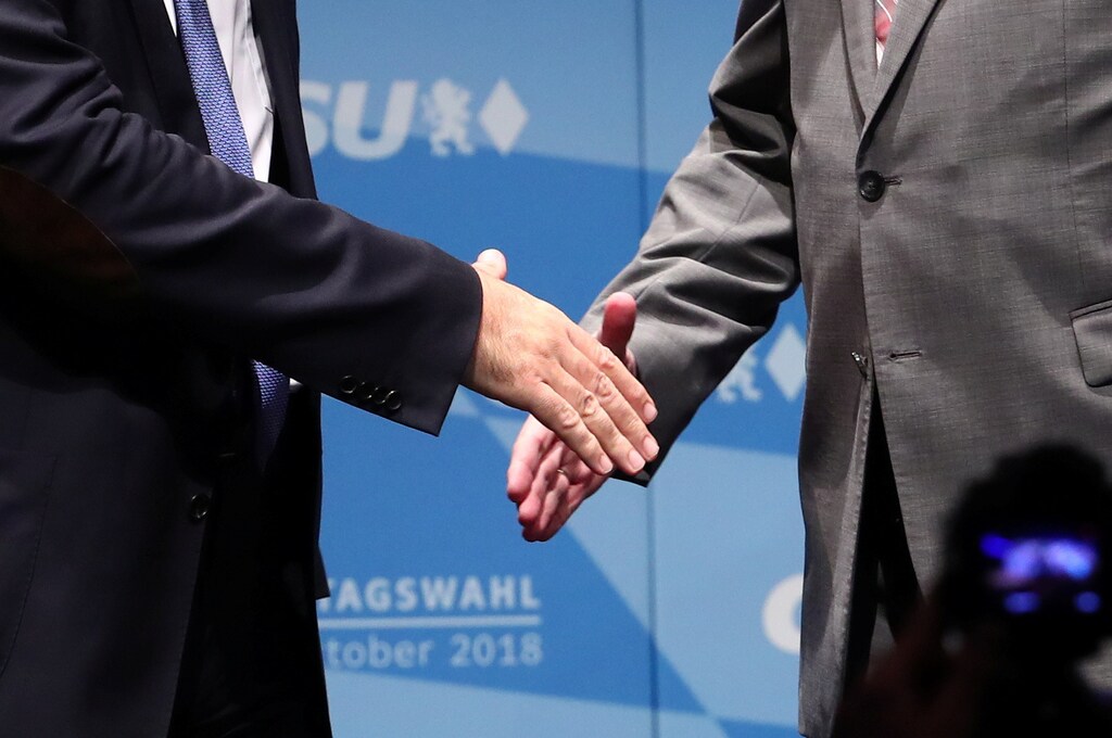 Leader of the Christian Social Union (CSU) Horst Seehofer and Bavarian State Prime Minister Markus Soeder shake hands on stage during a CSU election campaign rally in Ingolstadt, Germany, October 8, 2018. REUTERS/Michael Dalder - RC1629CE9ED0