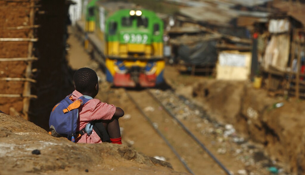 A child watches a train passing through the Kibera slum of Kenya's capital Nairobi February 26, 2015.
