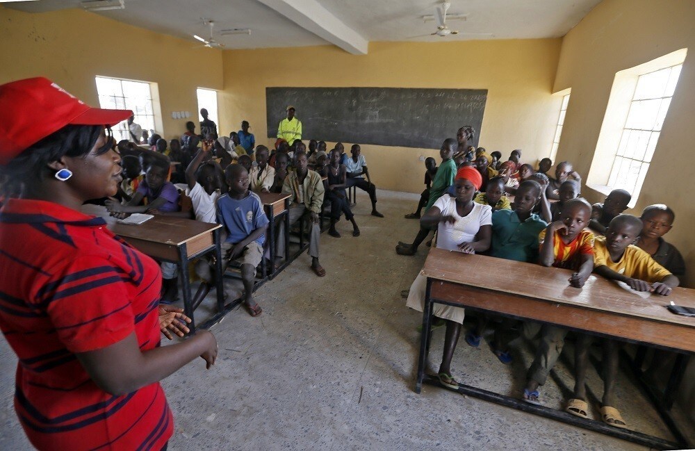 Children displaced as a result of Boko Haram attacks in the northeast region of Nigeria, attend class at Maikohi secondary school inside a camp for internally displaced persons (IDP) in Yola, Adamawa State January 13, 2015. Boko Haram says it is building an Islamic state that will revive the glory days of northern Nigeria's medieval Muslim empires, but for those in its territory life is a litany of killings, kidnappings, hunger and economic collapse. Picture taken January 13. To match Insight NIGERIA-BOKOHARAM/ REUTERS/Afolabi Sotunde (NIGERIA - Tags: CIVIL UNREST EDUCATION SOCIETY) - RTR4M2KN