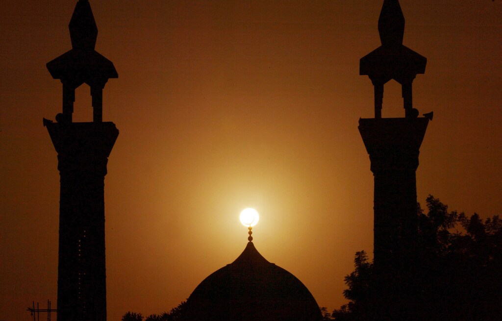 The sun sets behind a mosque during Ramadan in Dubai, UAE, October 16 2004. Ramadan, the ninth and holiest month of the Islamic lunar calendar, is a one month period of time during which devout Muslims refrain from all food, drink and sexual relations during daylight hours and focus on devotion alms and good deeds. REUTERS/Anwar Mirza. NO RIGHTS CLEARANCES OR PERMISSIONS ARE REQUIRED FOR THIS IMAGE. AM/ABP - RP5DRHZMJZAB