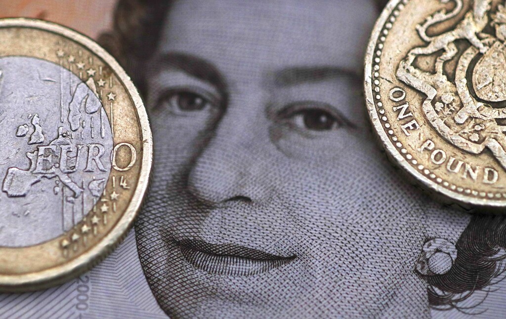A two Euro coin is pictured next to a one Pound coin on top of a portrait of Britain's Queen Elizabeth in this file photo illustration shot March 16, 2016.
