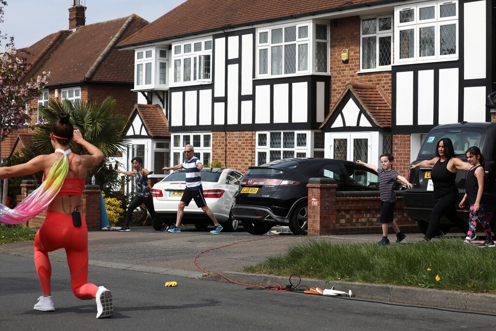 Residents of Chigwell Park Drive take part in a fitness class led by Elyse Blemmings, also known as the Mancunian Motivator outside their homes in Chigwell, Britain April 16, 2020. REUTERS/Simon Dawson - RC2G6G93WU2N