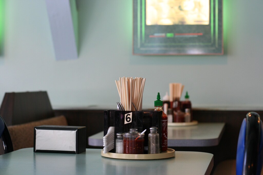 Chopsticks on a table with salt and other condiments.