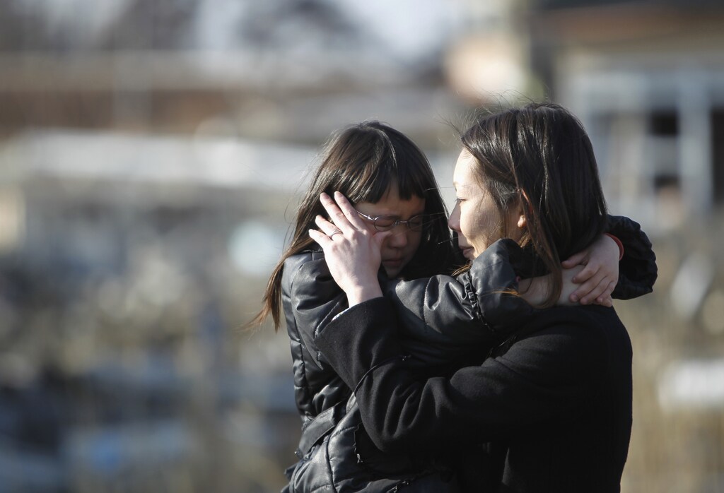 Wakana Kumagai, 7, and her mother Yoshiko cry as they visit the spot where their house, which was washed away by the March 11, 2011 tsunami, used to stand in Higashimatsushima, Miyagi prefecture March 11, 2012, to mark the first anniversary of an earthquake and tsunami that killed thousands and set off a nuclear crisis. Kumagai's father Kazuyuki called his wife Yoshiko just after the March 11, 2011 earthquake to tell her to take the children to Omagari elementary school which was serving as a shelter. He was found near the shelter four days after the tsunami, Yoshiko said. REUTERS/Toru Hanai (JAPAN - Tags: ANNIVERSARY DISASTER) - GM1E83B19S901