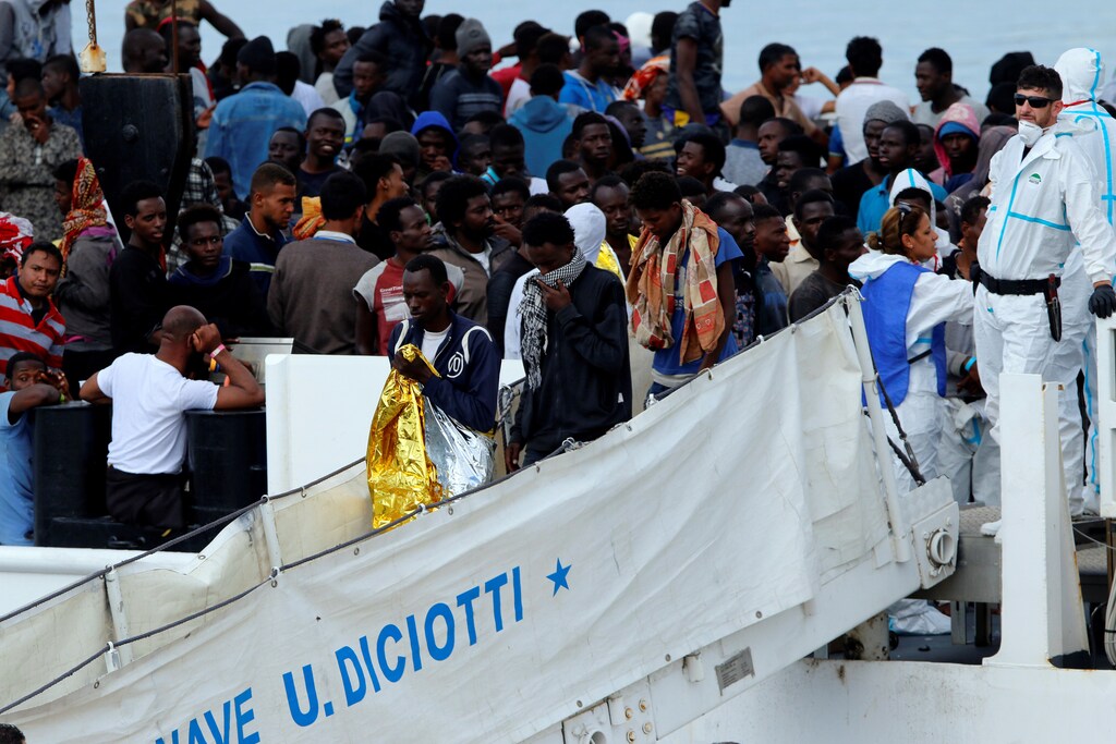 Migrants disembark Italian coast guard vessel "Diciotti" as they arrive at the port of Catania, Italy, June 13, 2018. REUTERS/Antonio Parrinello - RC1C6AA31A60