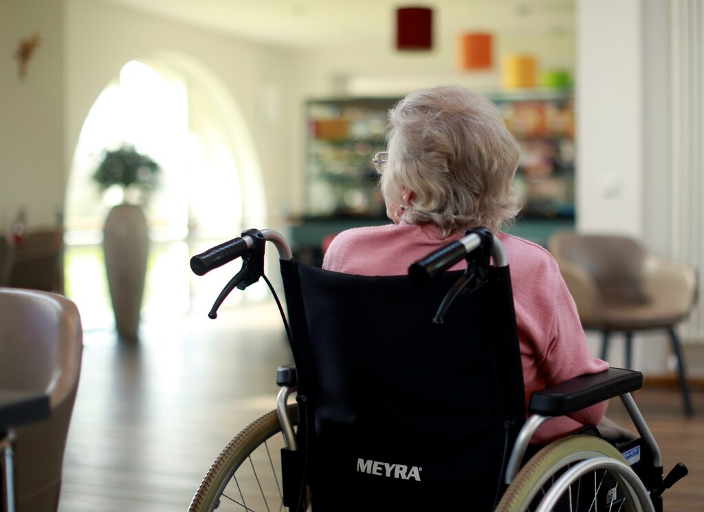 An elderly woman sits in the recreation room of a retirement home as visits have been restricted due to the coronavirus disease (COVID-19) concerns in Grevenbroich, Germany, March 16, 2020.