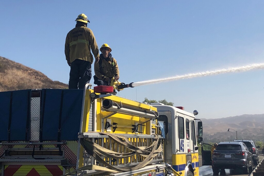 Firefighters direct water on a fire burning on a hillside near the Reagan Presidential library in Simi Valley, California, U.S. October 30, 2019. REUTERS/Omar Younis - RC188326AA30