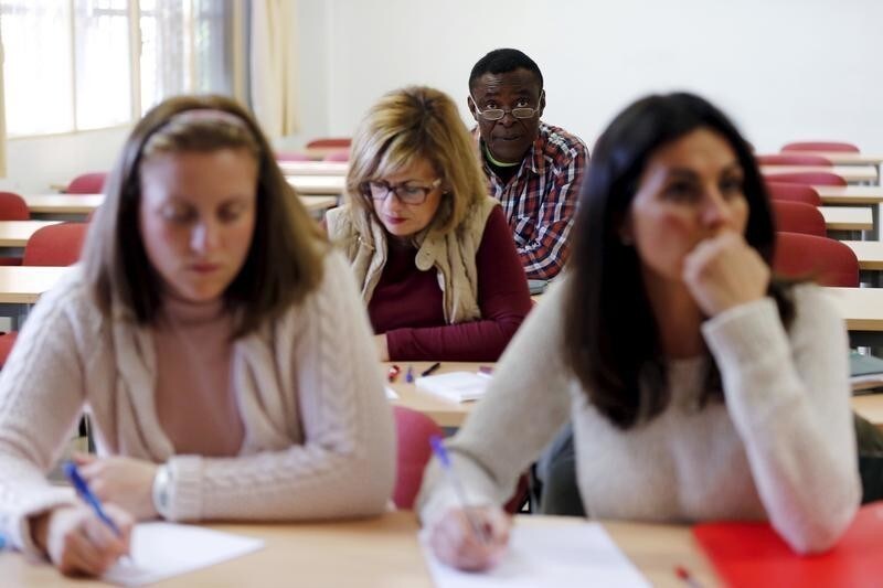 Howard Jackson, a Liberian migrant, attends a law class at a university in the Andalusian capital of Seville, southern Spain March 8, 2016. Jackson escaped civil war and spent three years crossing Africa before reaching Spain. Dressed up in one of his more than 200 costumes, from Peter Pan to Little Red Riding Hood, he is a well-known figure at an intersection entering the Spanish city of Seville where he has sold tissues to motorists for over a decade. Jackson is studying law and wants to become a judge. REUTERS/Marcelo del Pozo SEARCH "MIGRANT JACKSON" FOR THIS STORY. SEARCH "THE WIDER IMAGE" FOR ALL STORIES - GF10000350822